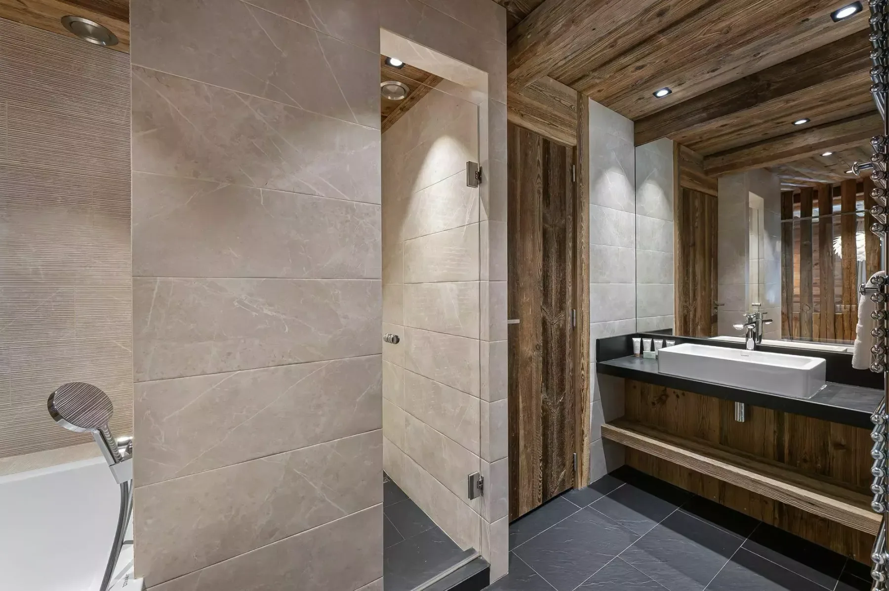 Un baño con ducha, lavabo y superficies revestidas de madera.