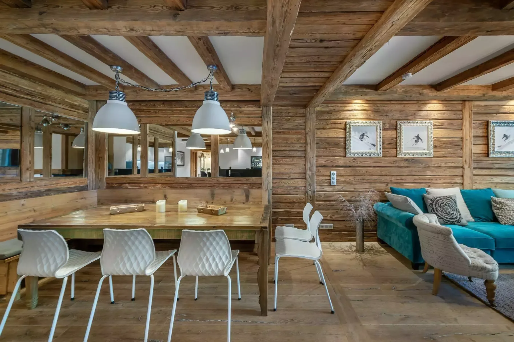 Un comedor rústico con una larga mesa de madera junto a una zona de estar.