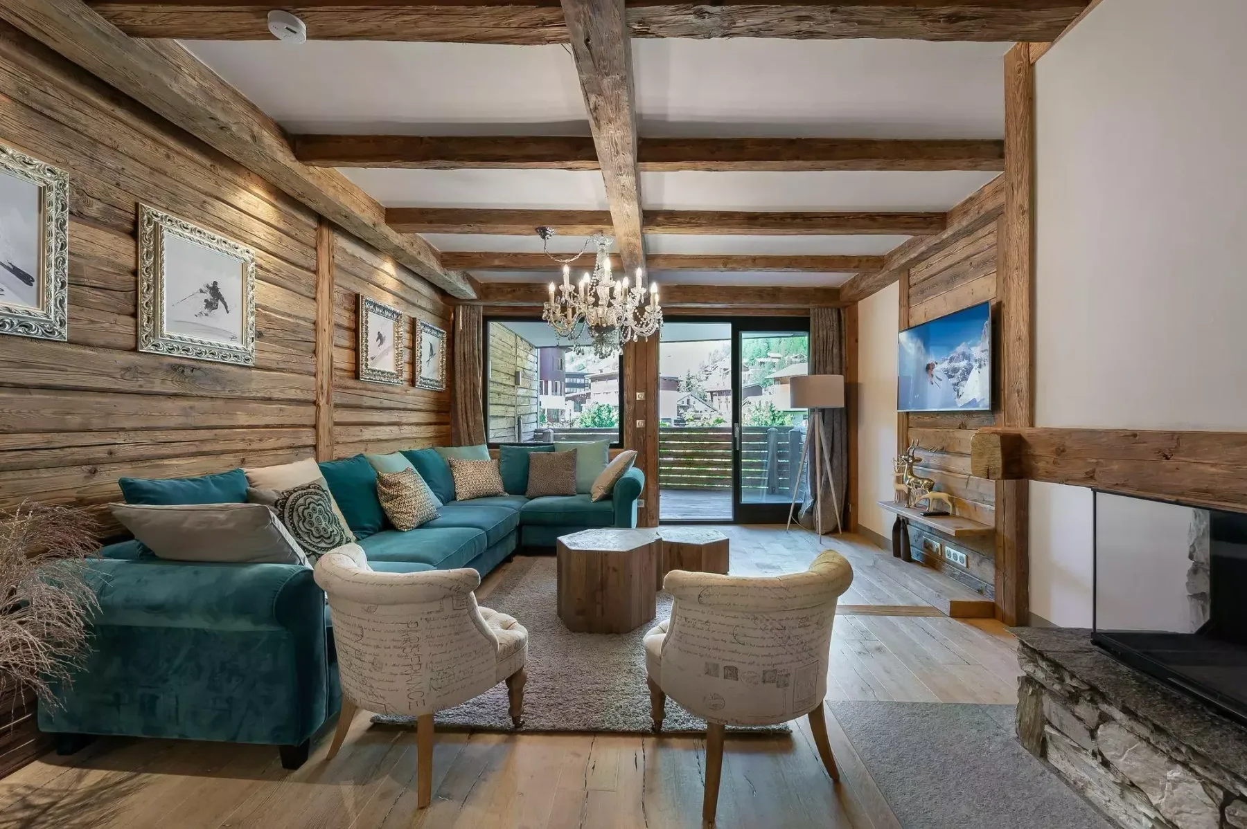 Una sala de estar con asientos color turquesa, una mesa baja y vigas de madera vistas.