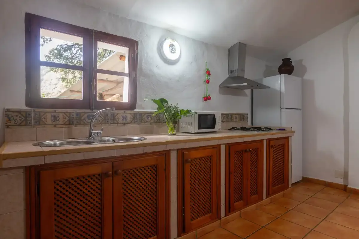 A kitchen with a long counter, sink, and window.