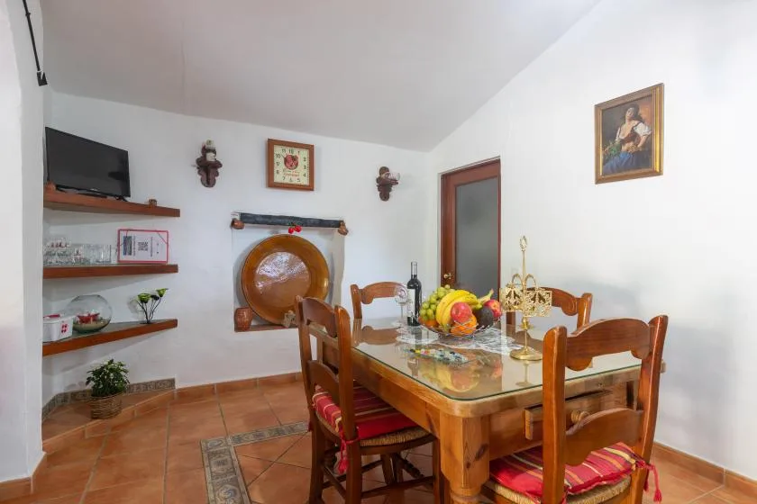A dining room with a wooden table and chairs beneath framed wall art.