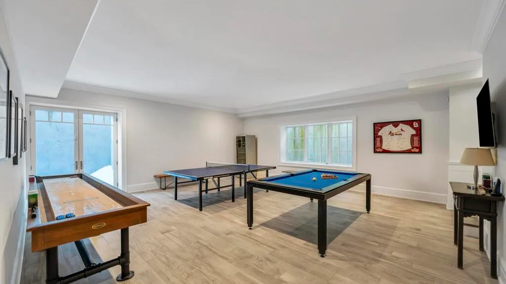 Una sala de juegos con mesas de billar y una mesa de ping-pong.