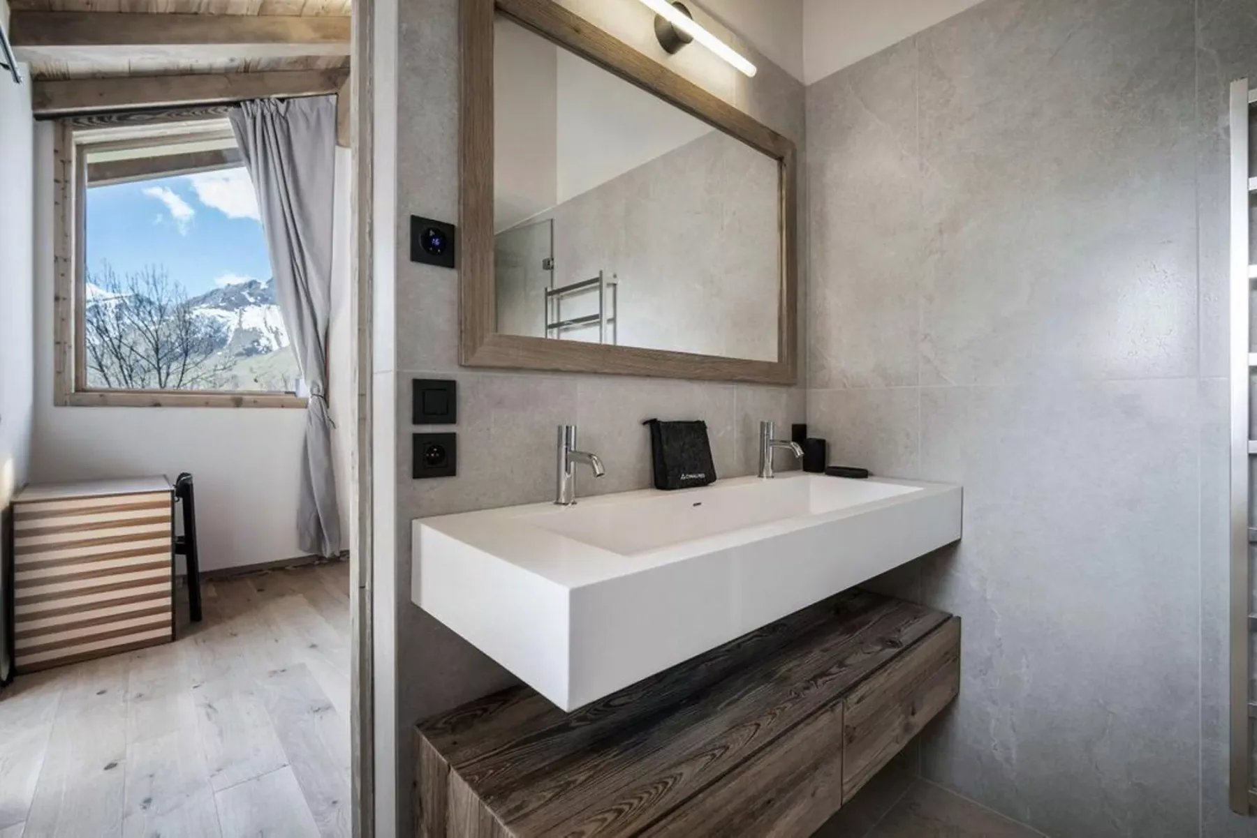 Un lavabo amplio ocupa el baño bajo un espejo grande.
