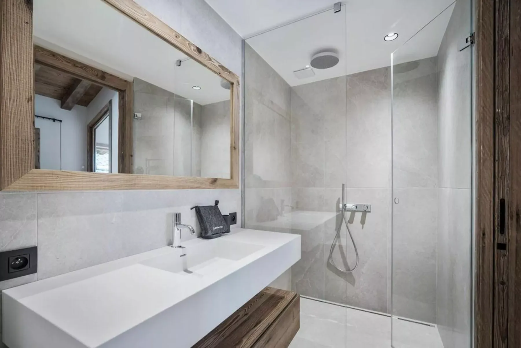 Un baño moderno con una encimera larga y una ducha de cristal.
