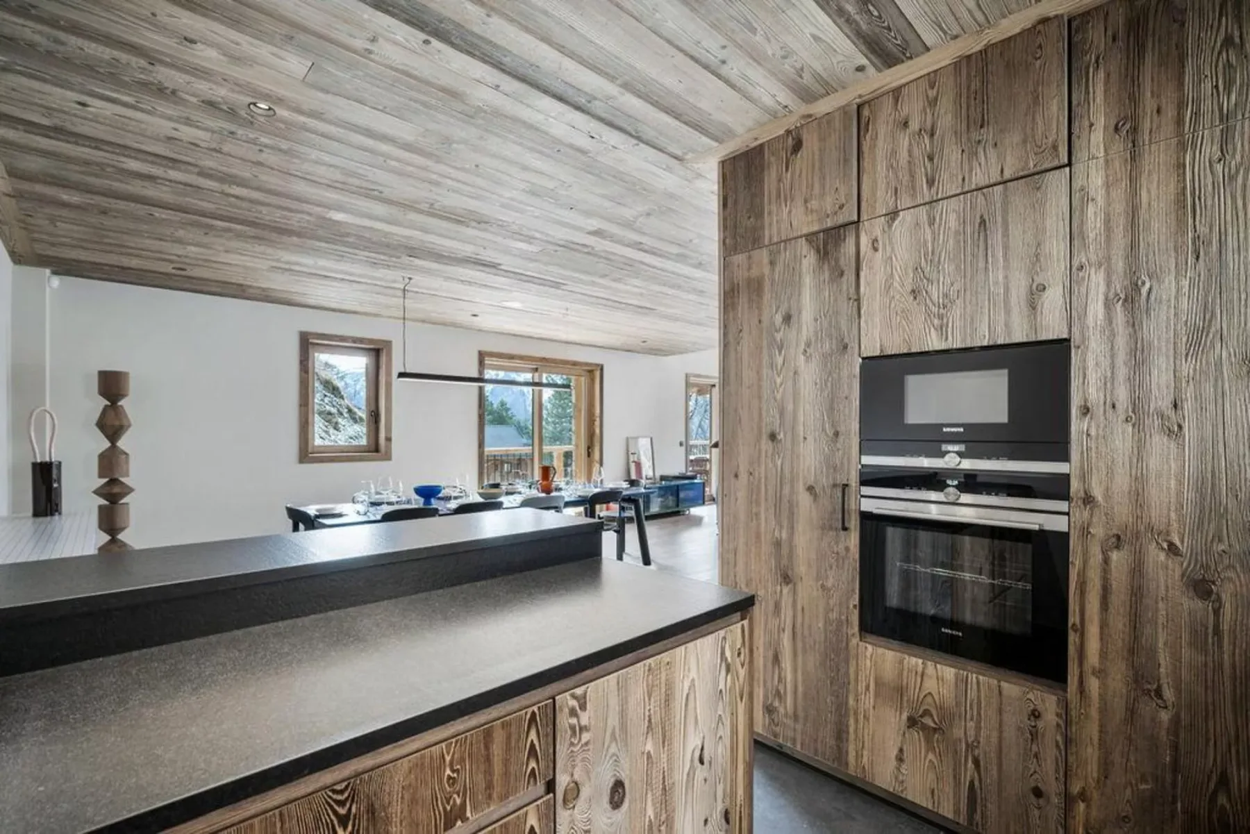 A modern kitchen with a long island and built-in oven.