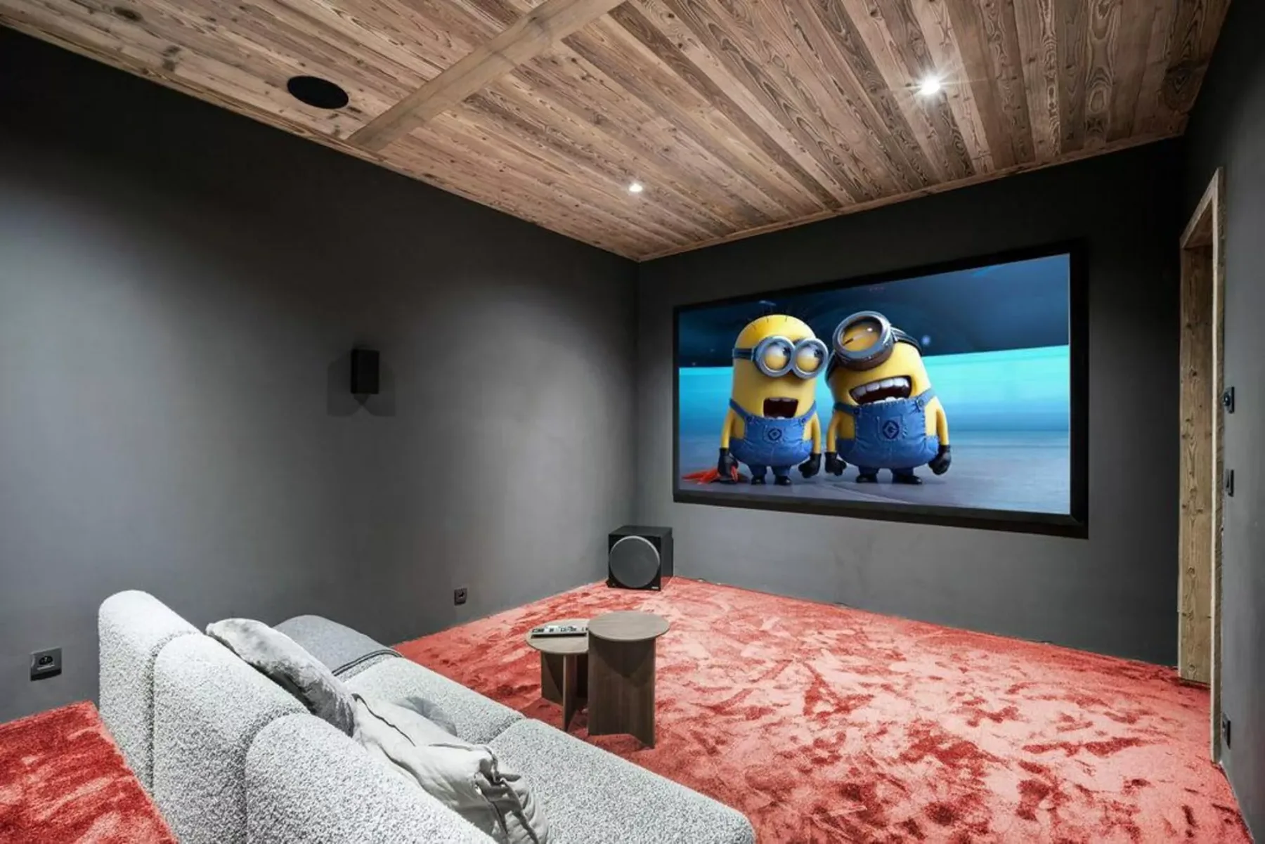 A home theater with cushioned seating facing a large screen.