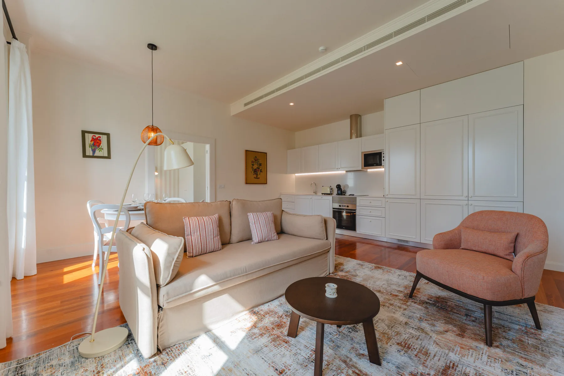 A bright living room with seating and a compact kitchen.