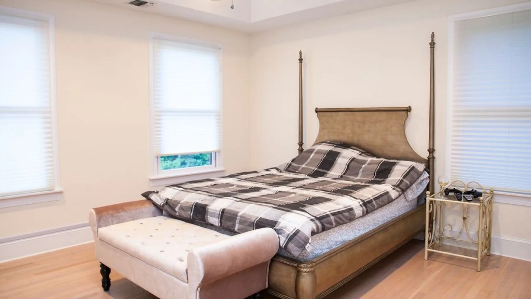 Un dormitorio con una cama grande y un banco acolchado a los pies.