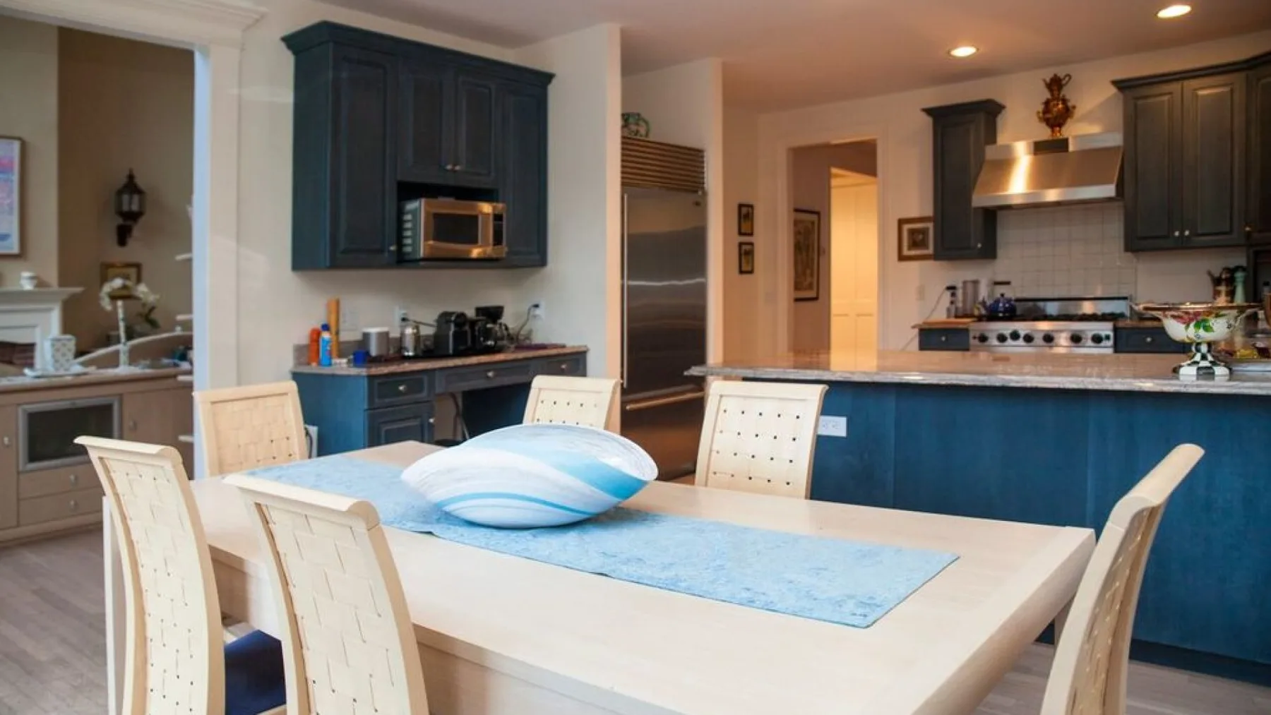 Una cocina amplia con gabinetes oscuros y una mesa de comedor en primer plano.