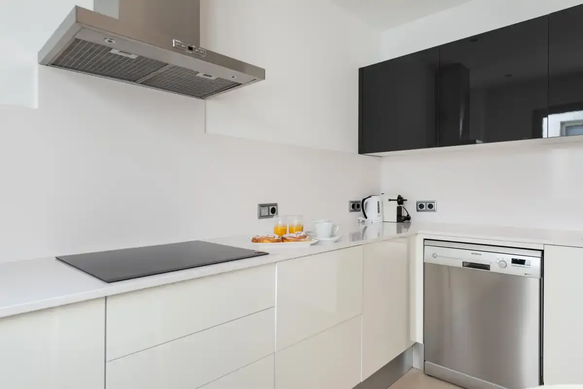 A modern kitchen with a cooktop, countertop appliances, and a dishwasher.