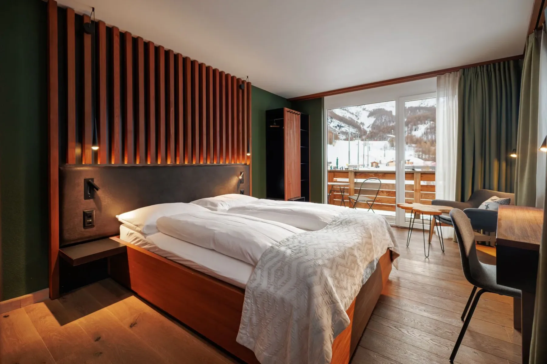 Bedroom with wood paneling and balcony doors.