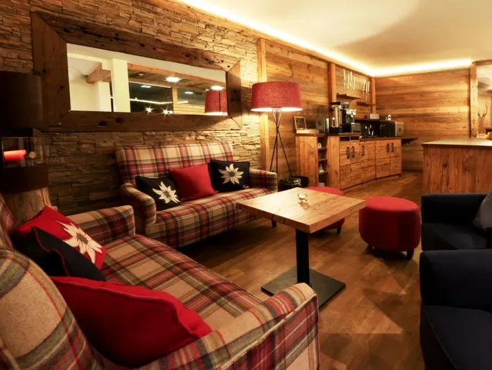 Hotel lounge with plaid sofas, red lamps and wooden walls.