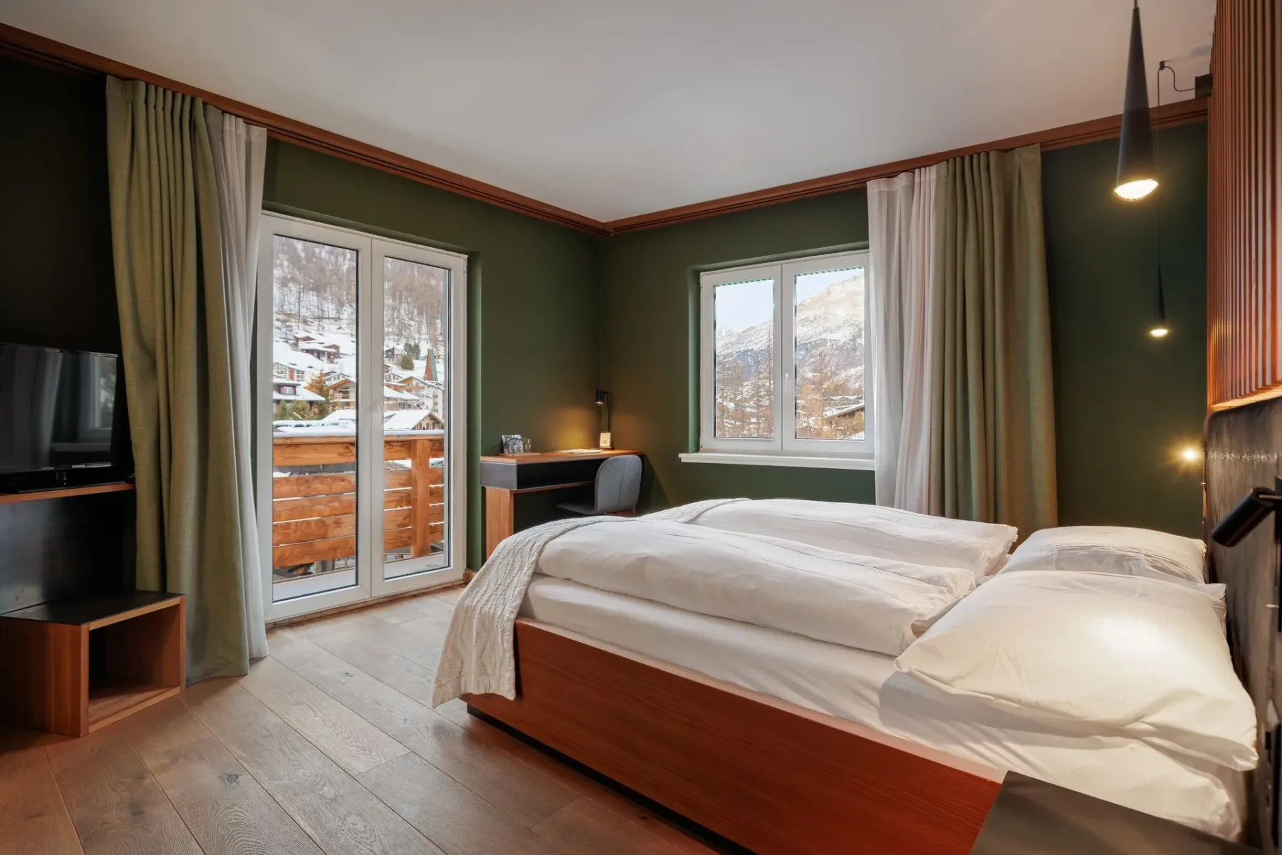 Bedroom with wooden bed and green walls.