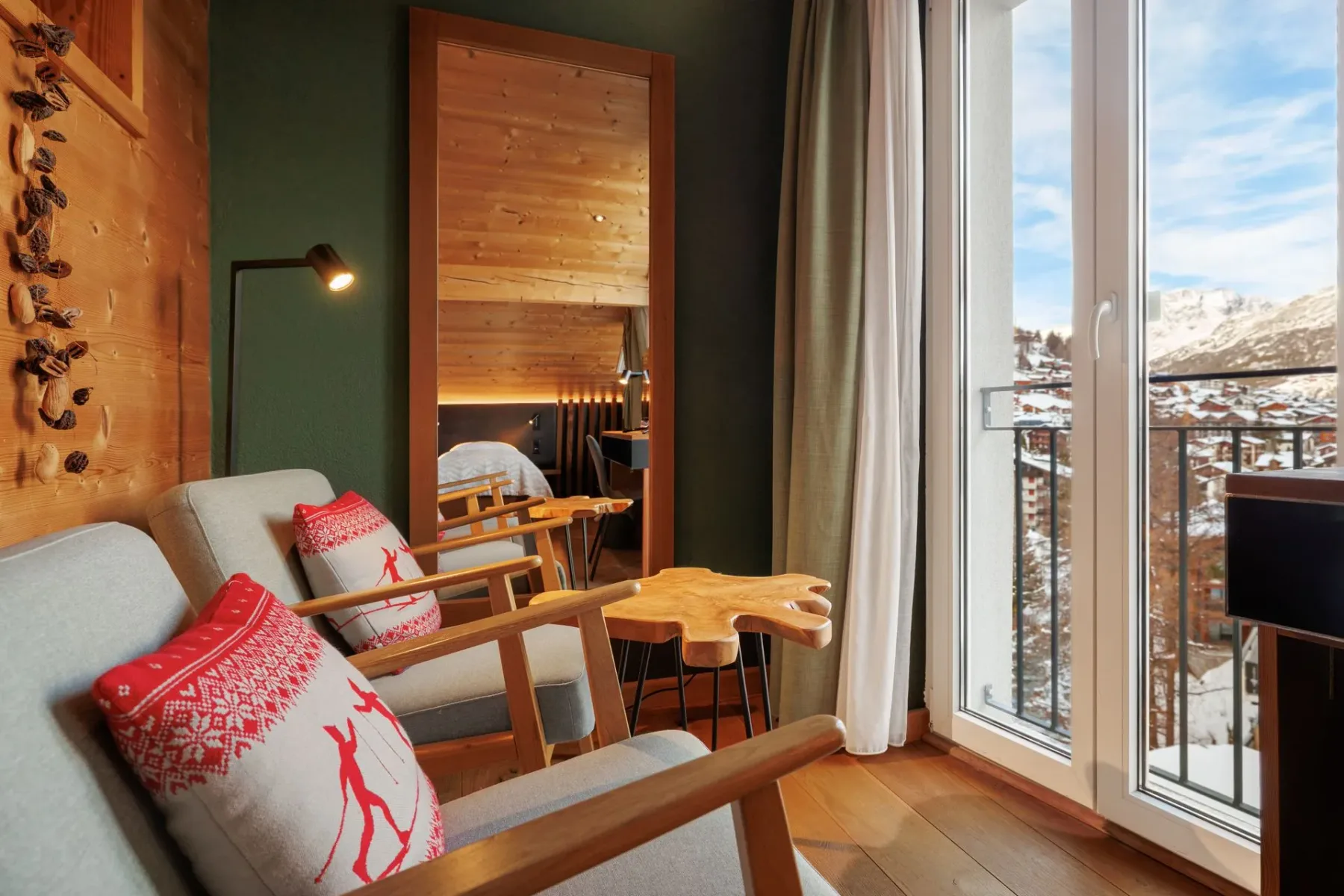 Living area with red pillows, wood accents and balcony windows.