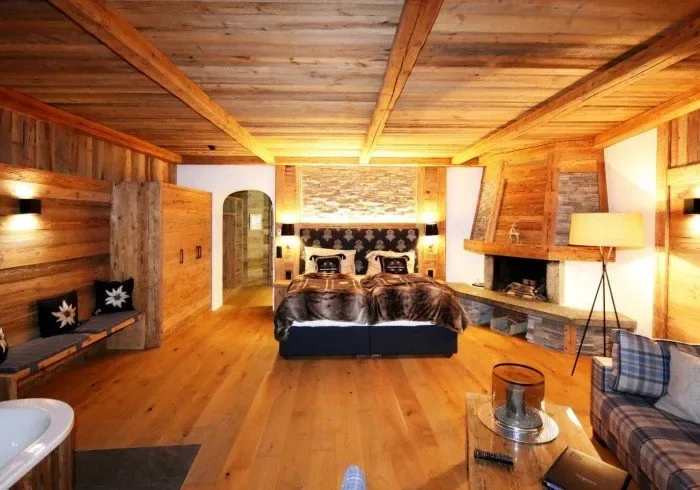 Bedroom with king bed and stone fireplace.