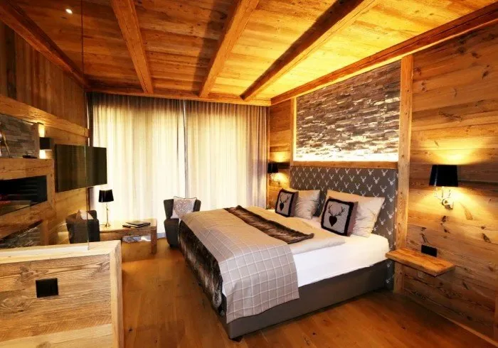 Wooden bedroom with a large bed and curtained window.