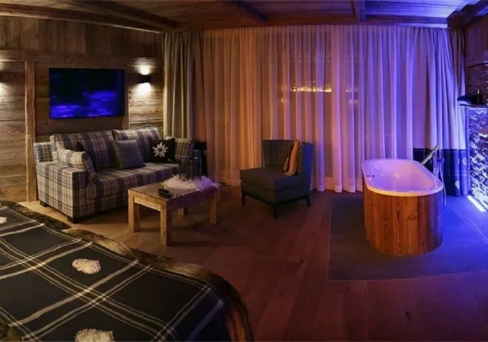 Wood-paneled lounge with sofa and bathtub.