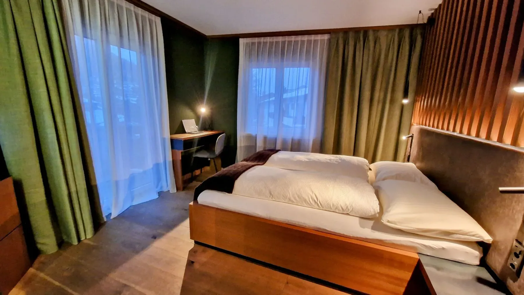 Bedroom with wood accent wall and balcony doors.