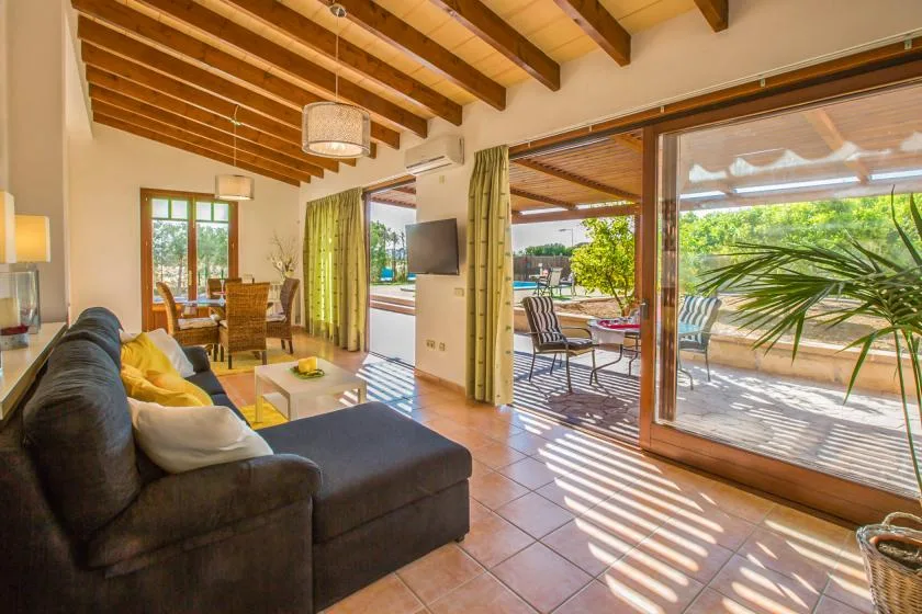 A living room opens onto a patio through wide glass doors.