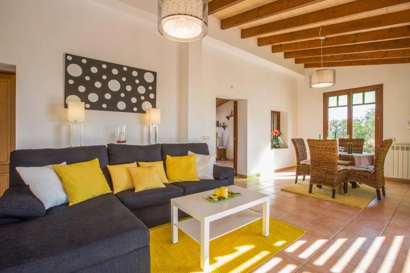 A living and dining room with a sectional sofa and a table beside the windows.