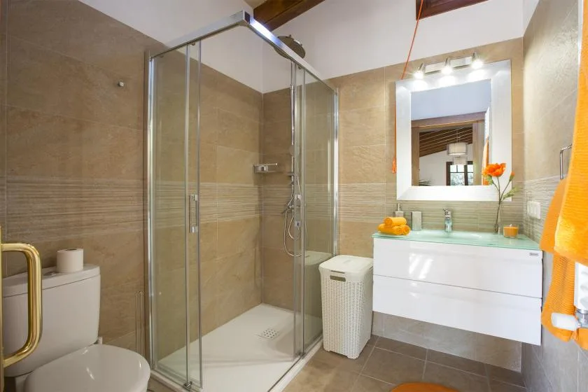 A tiled bathroom with a glass shower and a white vanity.