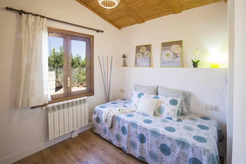 A bright bedroom with a daybed beneath a sloped wooden ceiling.