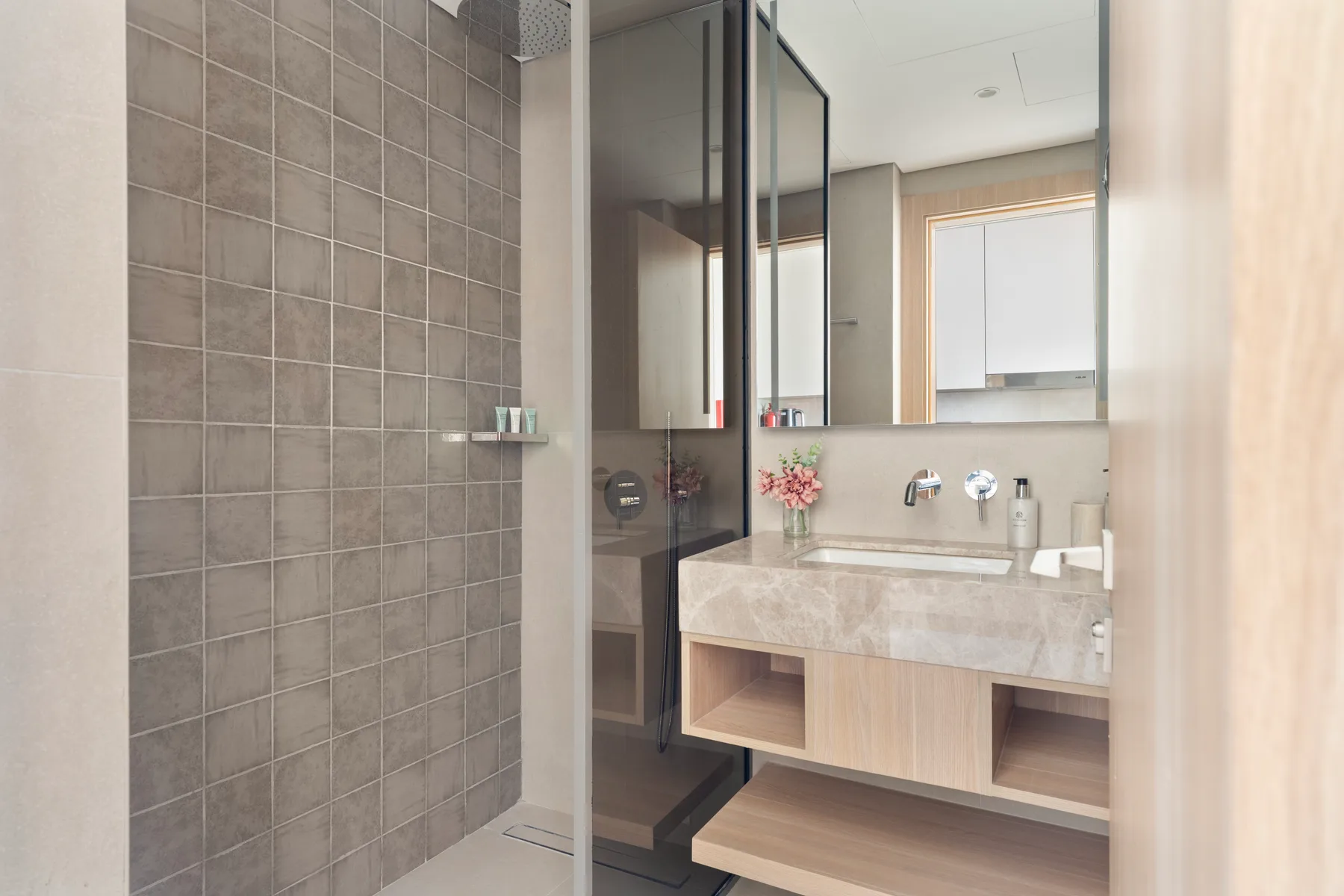 Un baño moderno con una ducha de vidrio y un lavabo con mueble.