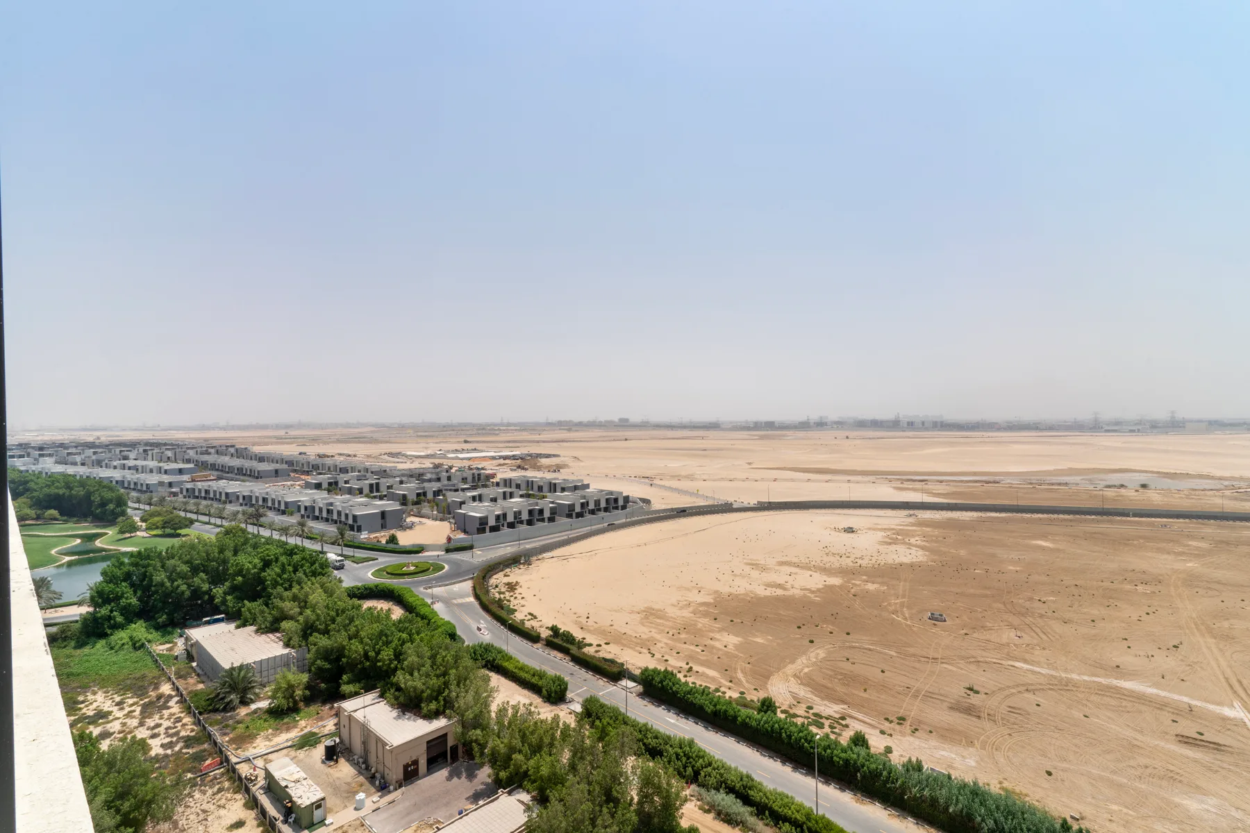 Vista aérea de un conjunto residencial junto a un amplio paisaje arenoso.