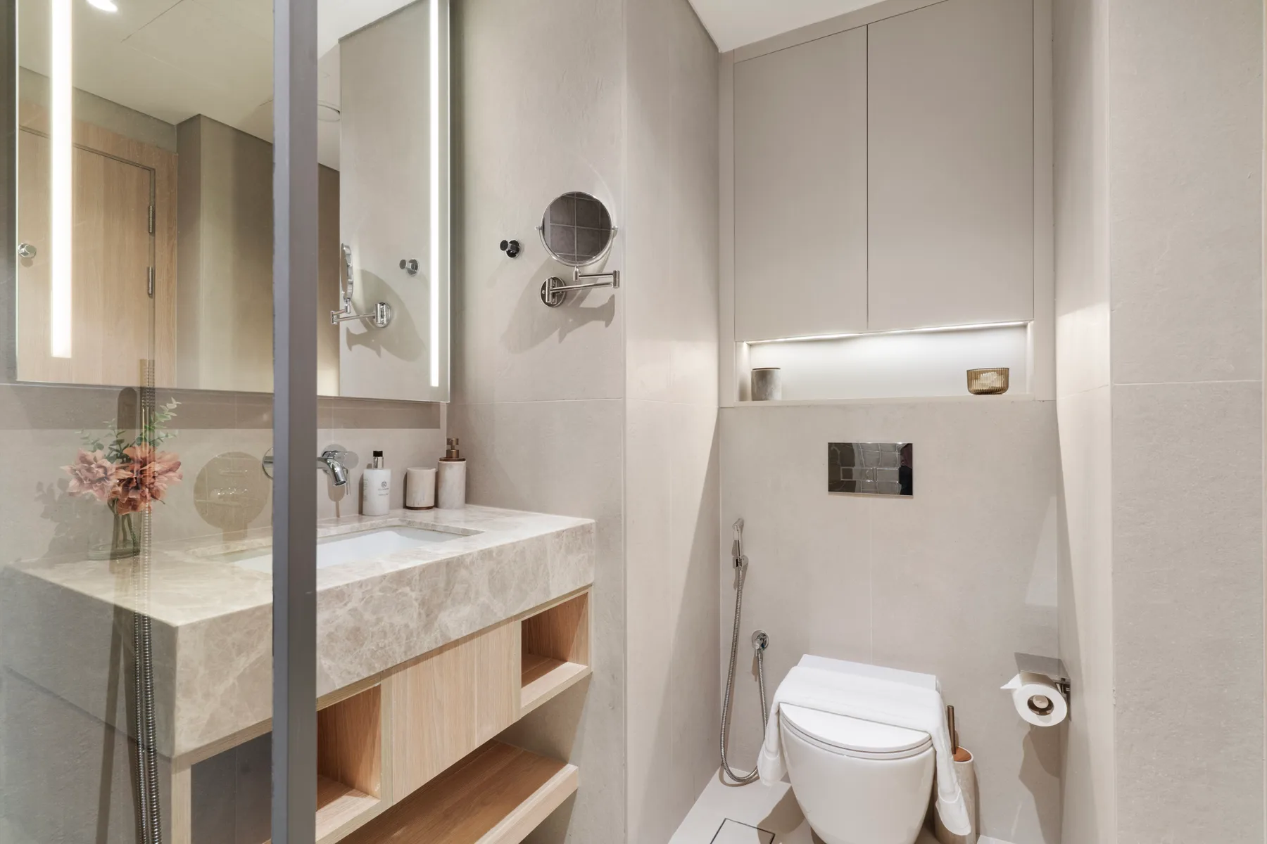 Un baño moderno con lavabo, espejo e inodoro.