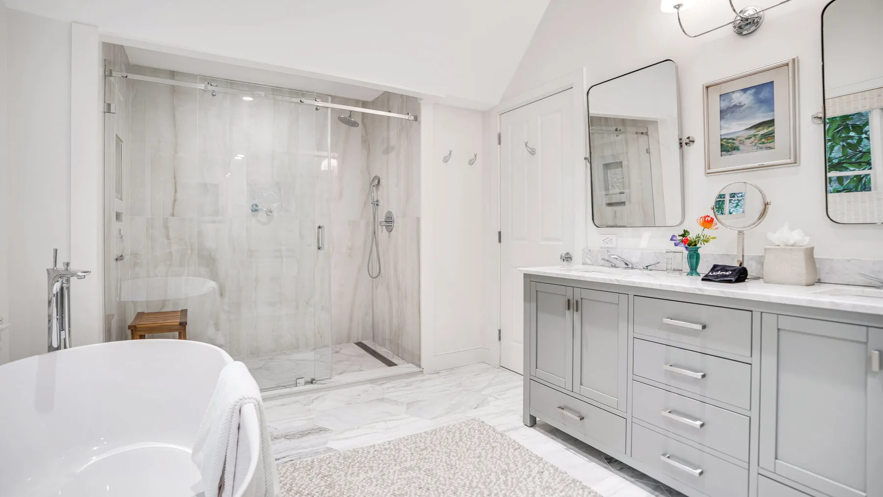 Un baño luminoso con bañera, ducha y mueble de lavabo.