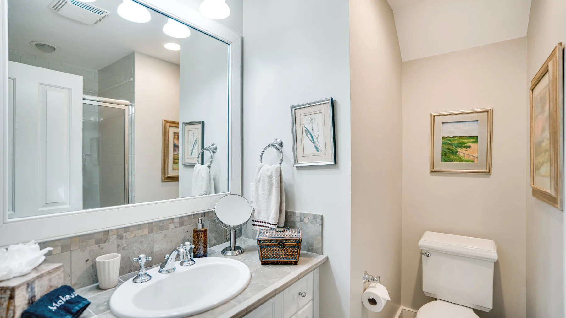 Un lavabo y un espejo en el baño, con un inodoro al lado.