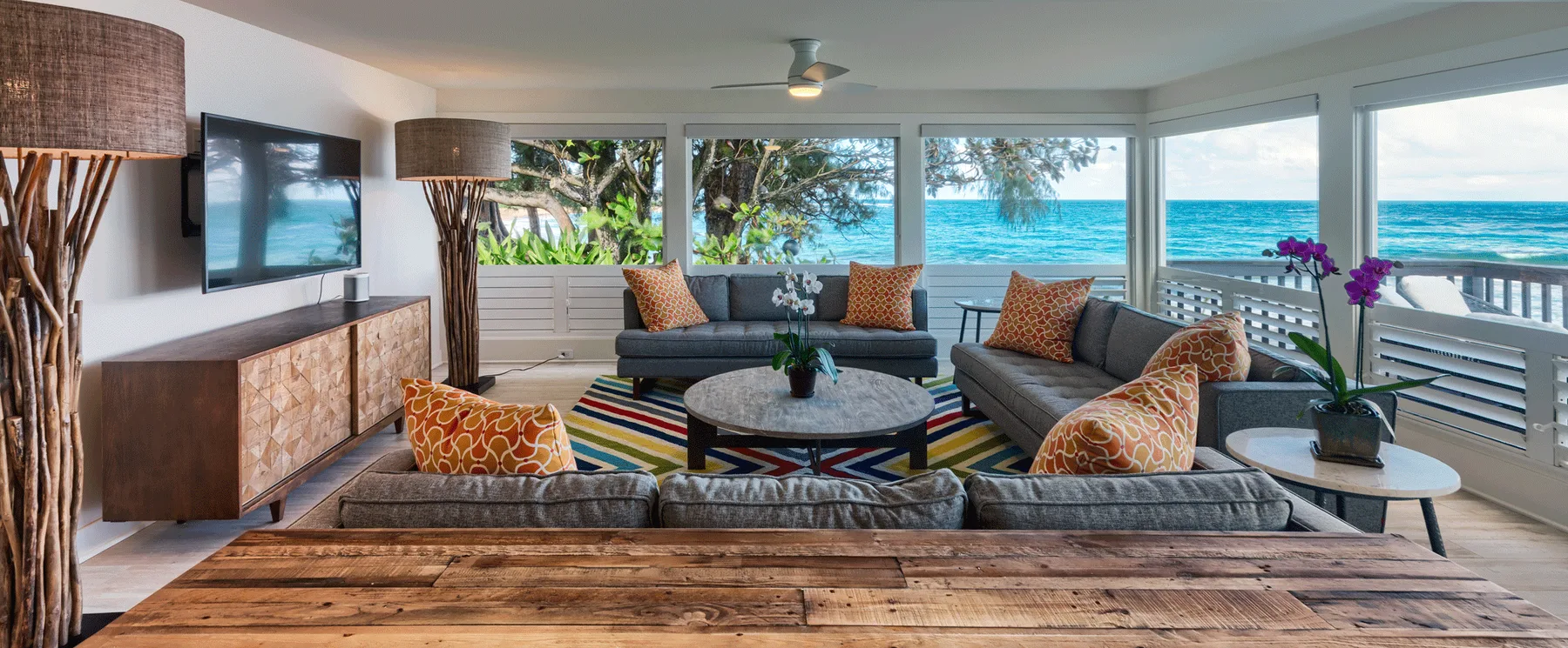 Una sala de estar se abre a una vista al mar, con asientos alrededor de una mesa de centro.