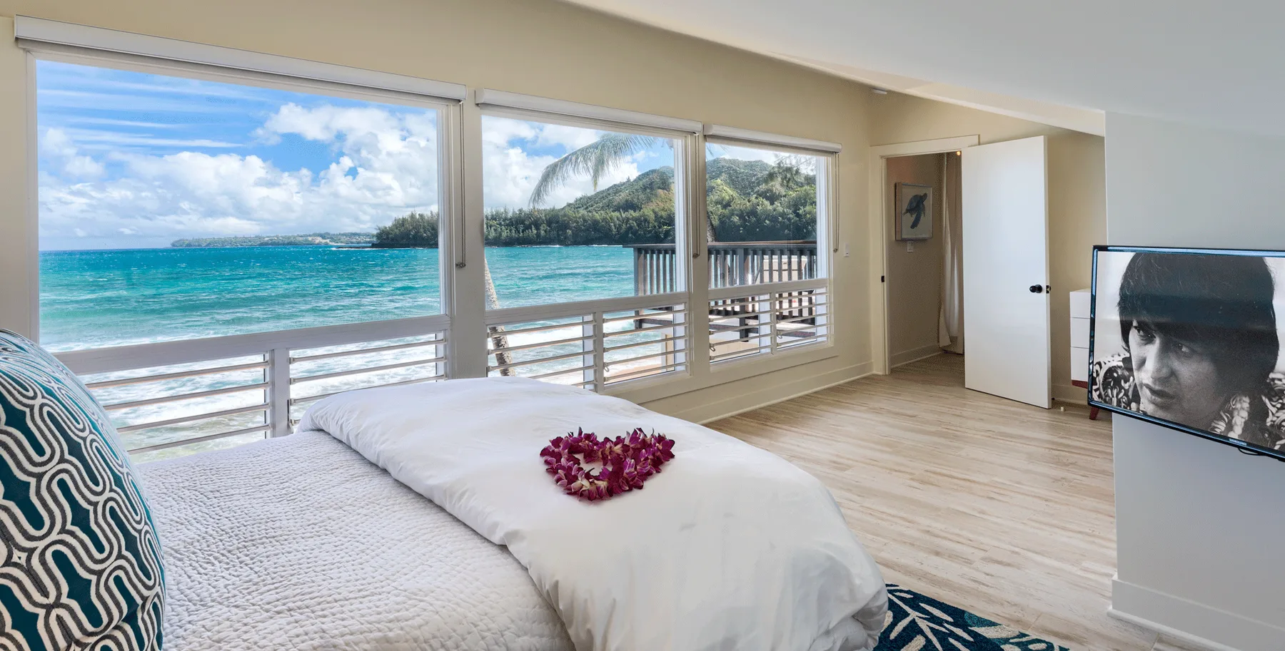 Un dormitorio con una cama junto a amplias ventanas con vista al mar.