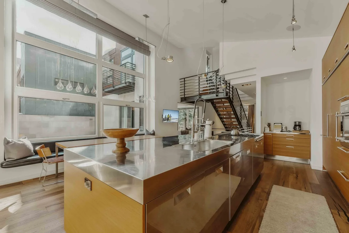 A bright open-plan kitchen with a large island and a staircase.