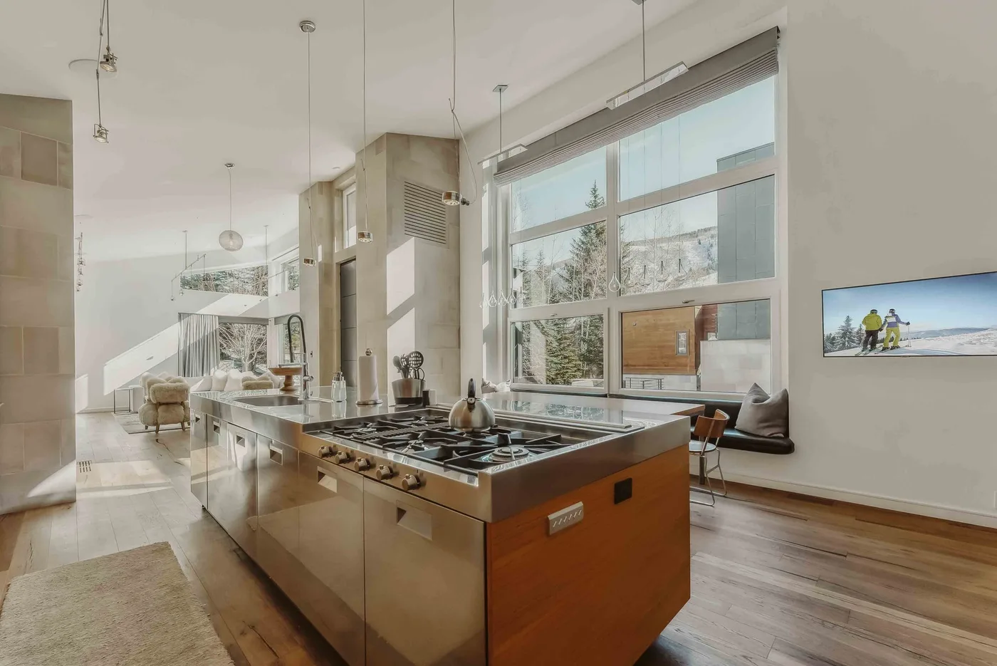 A bright kitchen with a large central island and wide windows.