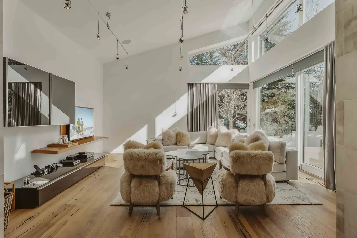 A bright living room with seating arranged beside large windows.