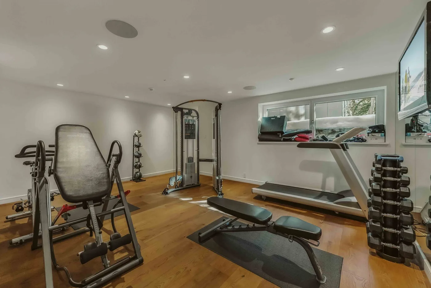 A home gym with exercise equipment, weights, and a treadmill.