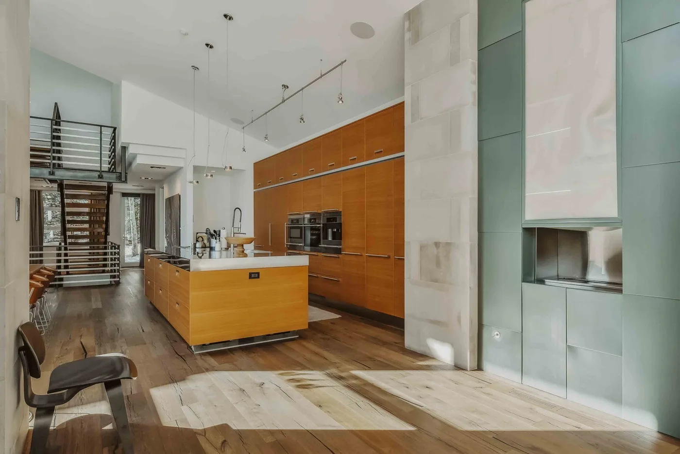 A modern kitchen with a central island and wood cabinetry.