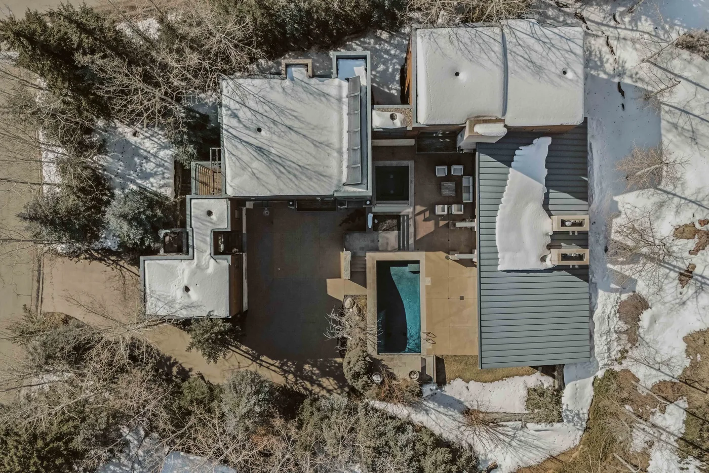 An overhead view shows a house and its snow-covered surroundings.