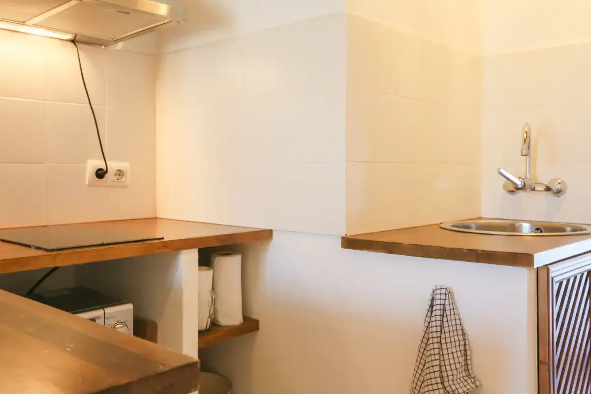 A compact kitchen with a stovetop, counter, and sink.