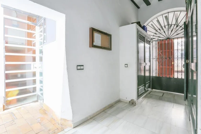 A bright entry hall with a barred window and a glass-fronted cabinet.