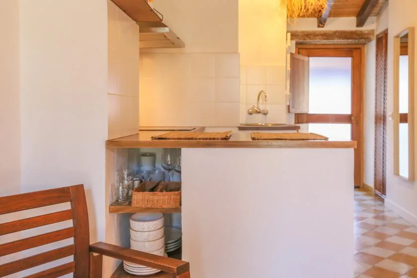 A compact kitchen with a counter and sink beside a bright window.