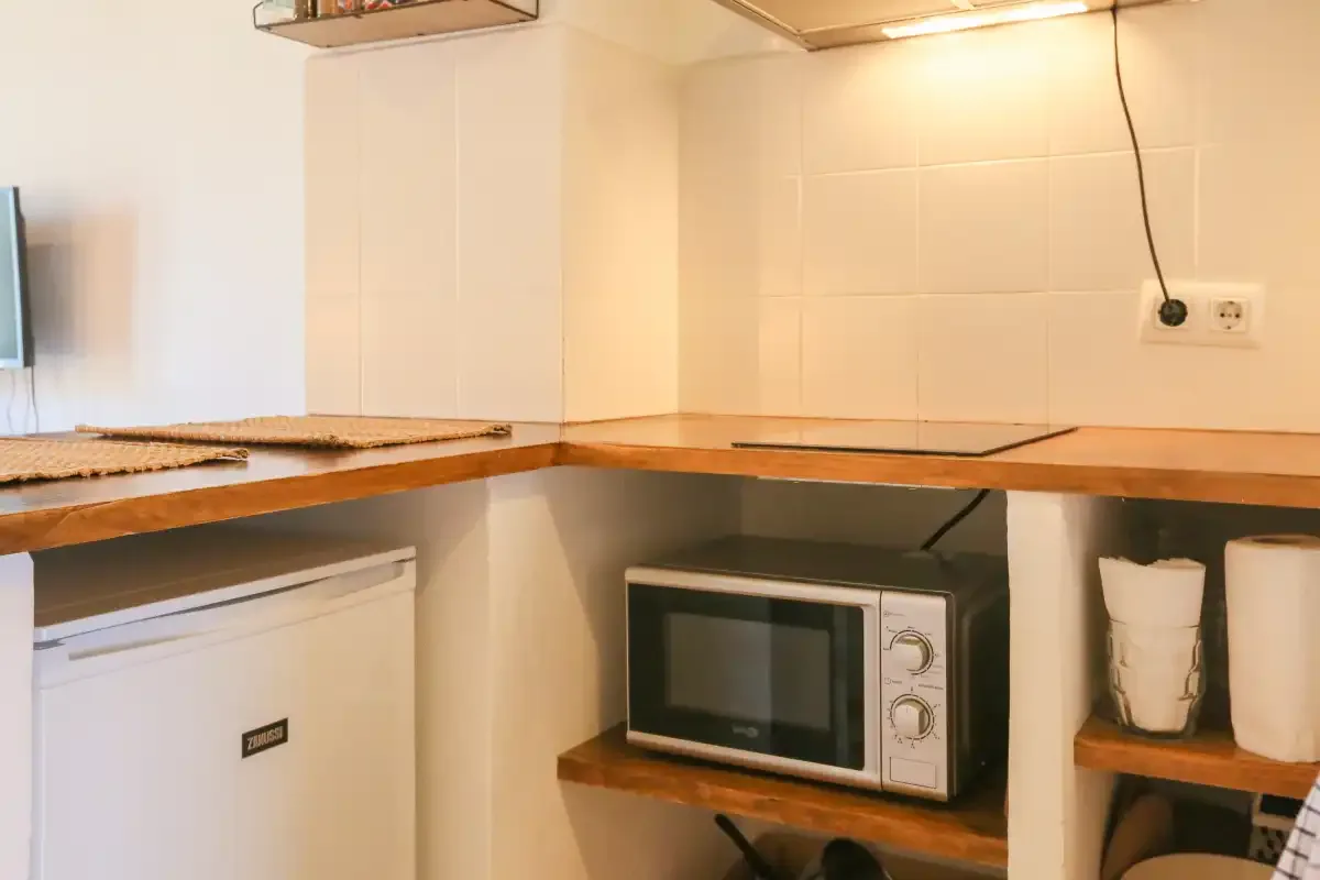 A compact kitchen counter with a microwave beneath the cabinets.