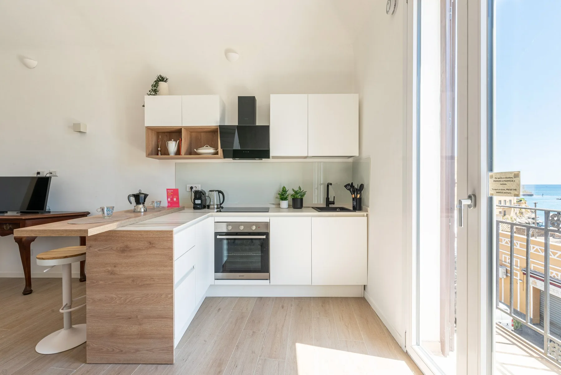 Una cocina luminosa con armarios blancos, un horno central y una isla.