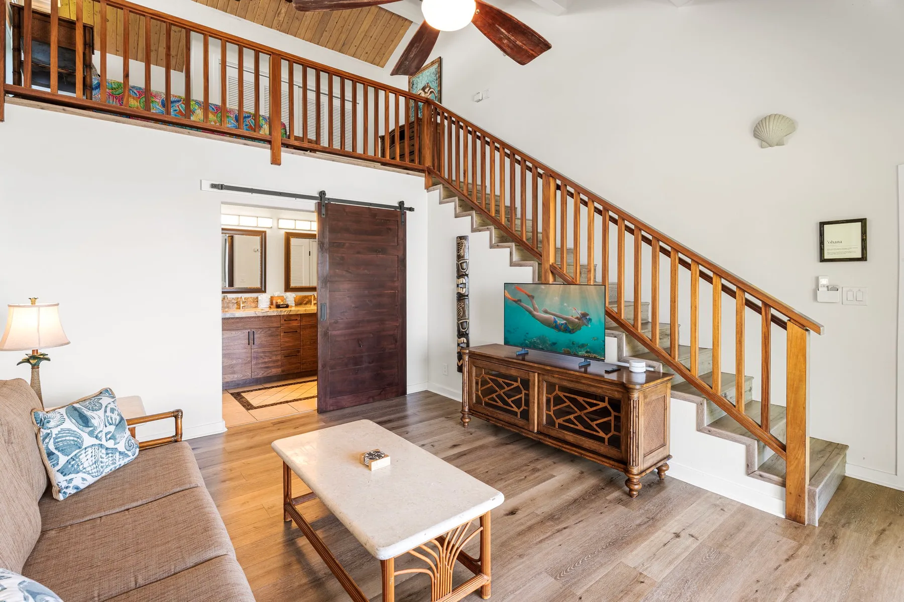 Sala de estar con una escalera de madera y zona de asientos.