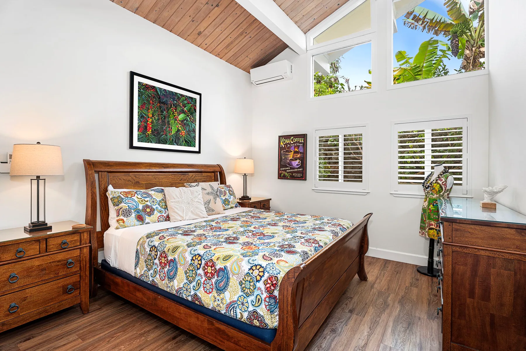 Un dormitorio luminoso con una cama de madera y ropa de cama estampada y colorida.