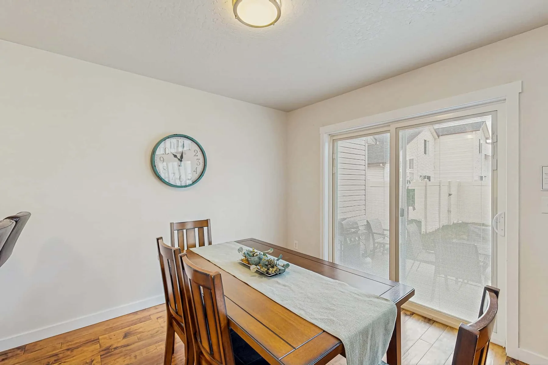 A dining area with a wooden table and chairs beside a large window.
