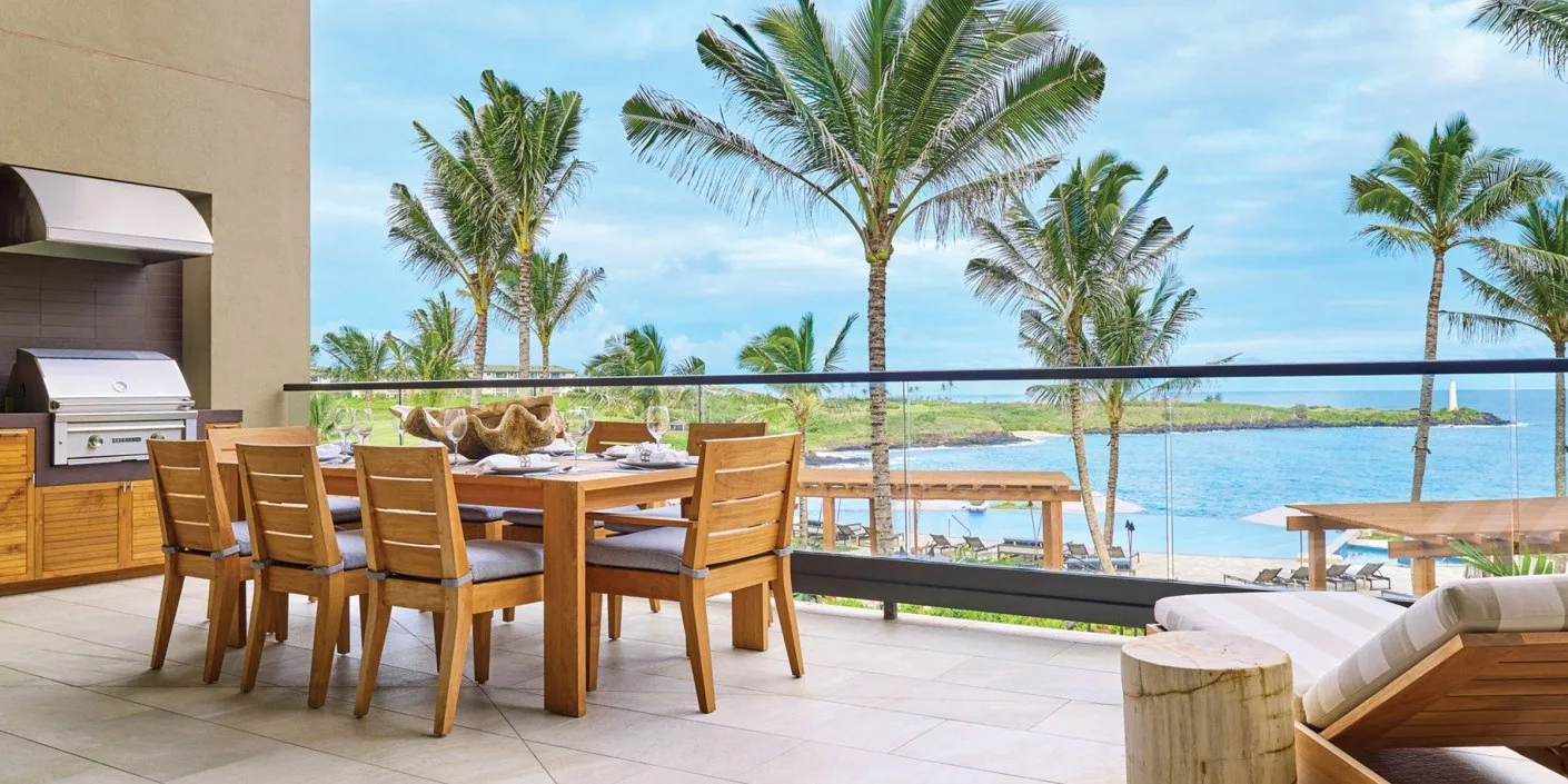 Una terraza con comedor al aire libre ofrece vistas a palmeras y al agua.