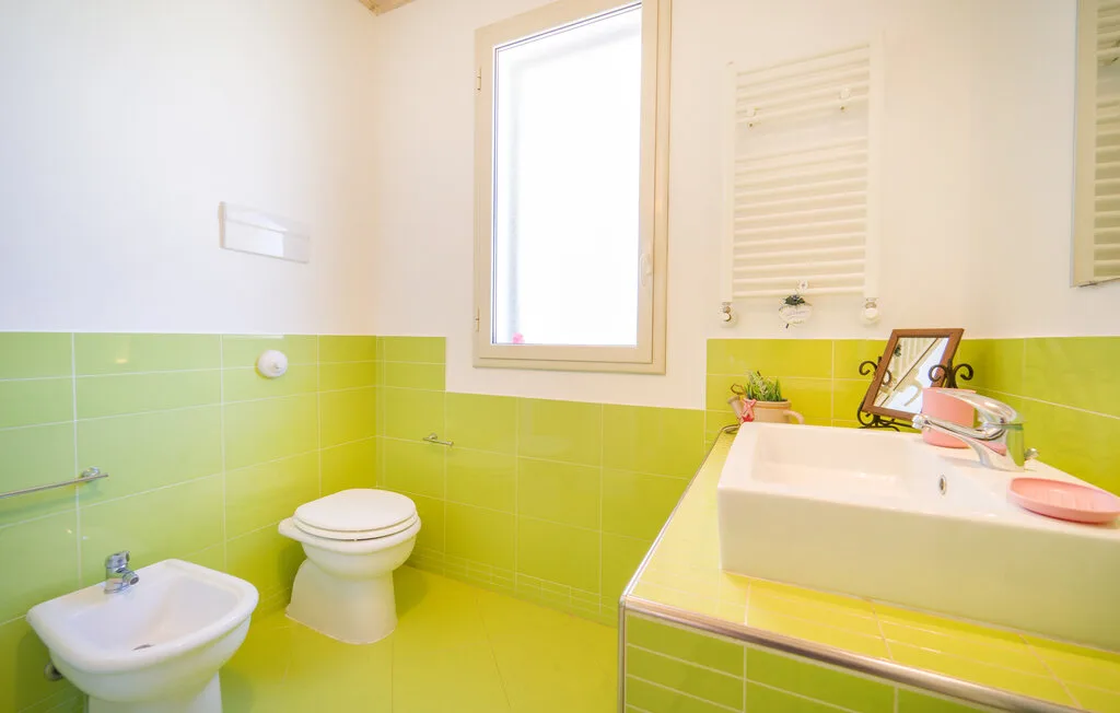A bright bathroom with a white bathtub, sink, and toilet.