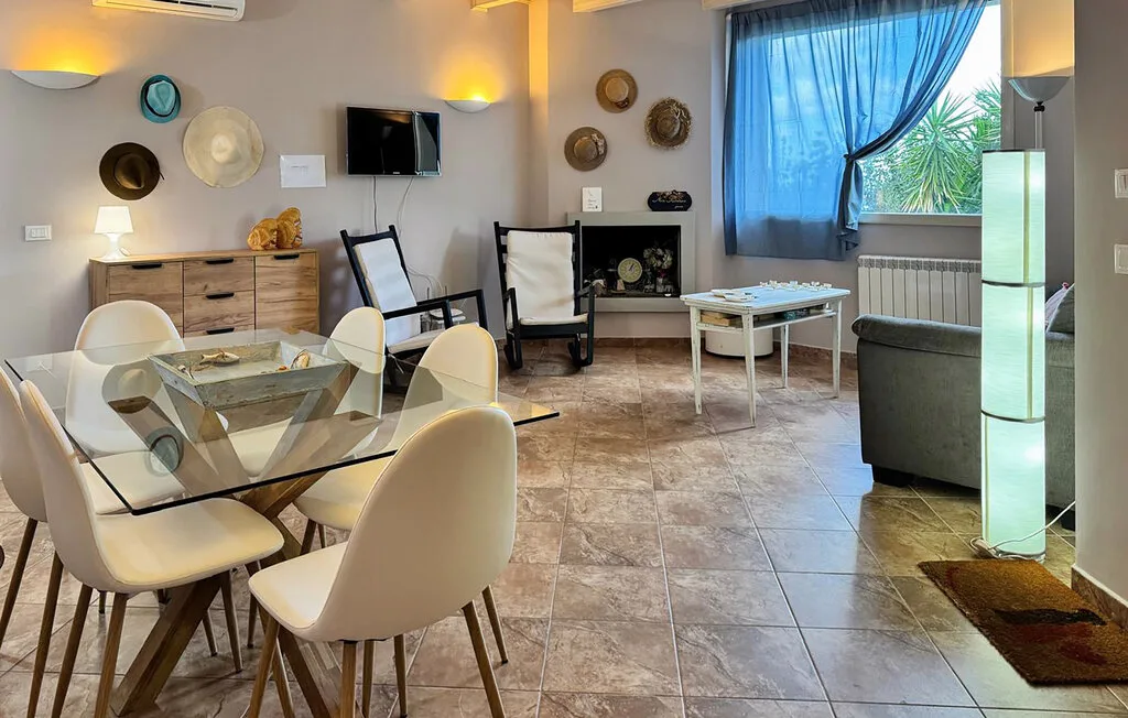 A bright living and dining area with a glass dining table and seating.